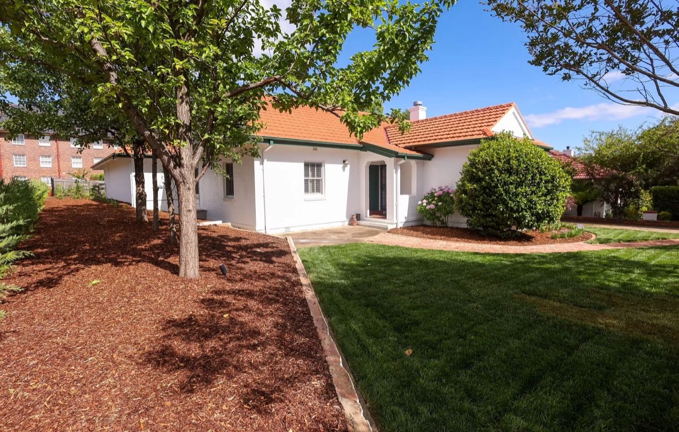 Barton: heritage cottage with re-established lawn, garden edging and mature tree canopy