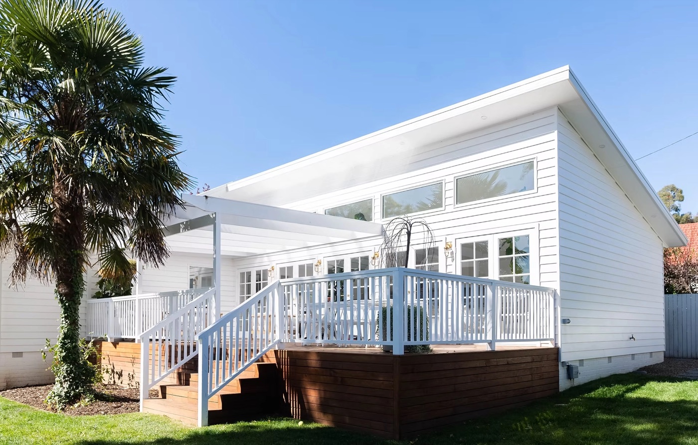 Buxton Street Deakin: white weatherboard home with raised hardwood deck and white balustrade