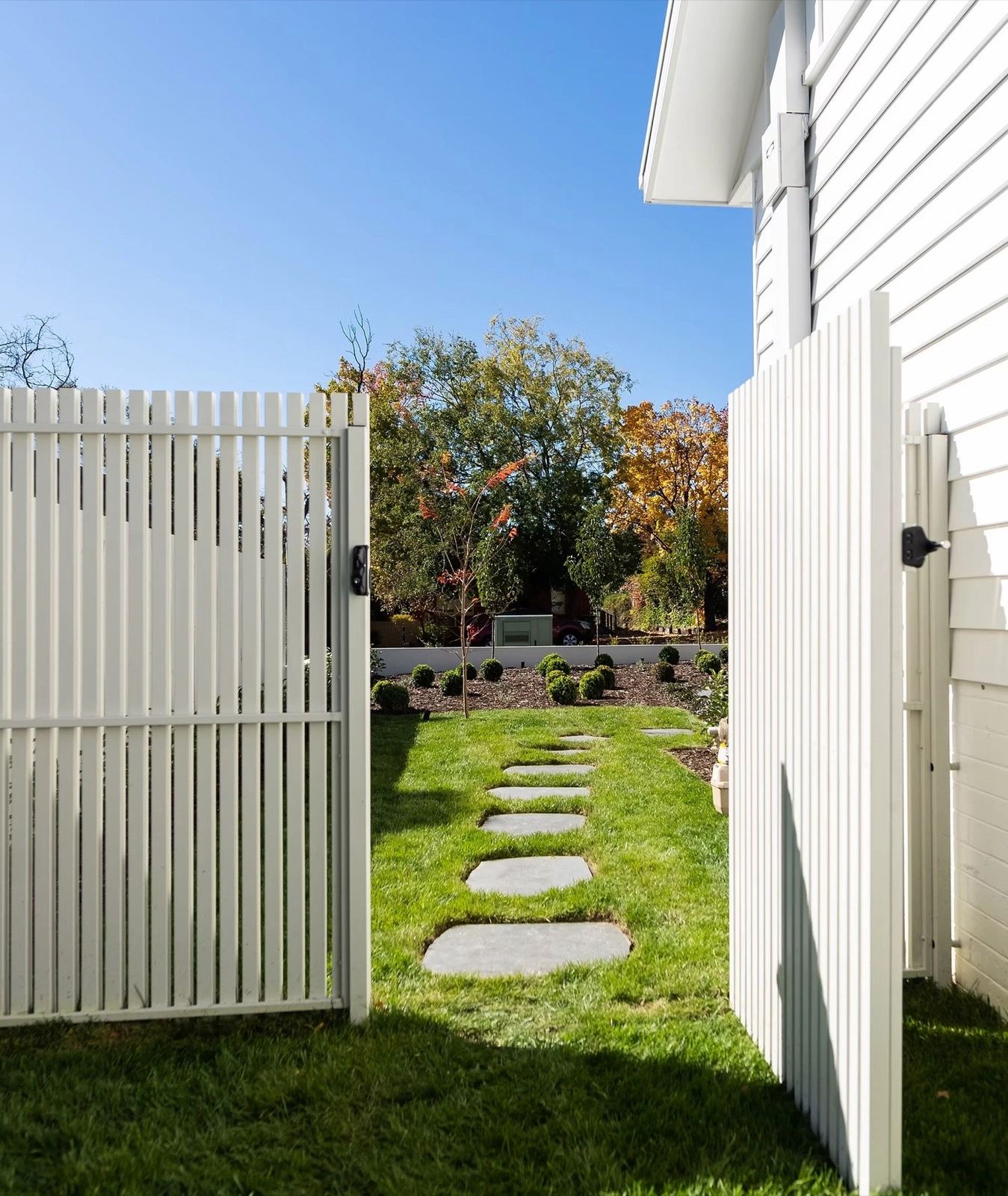 Front entry steps with white brick planter, new shrubs and stepping stone path