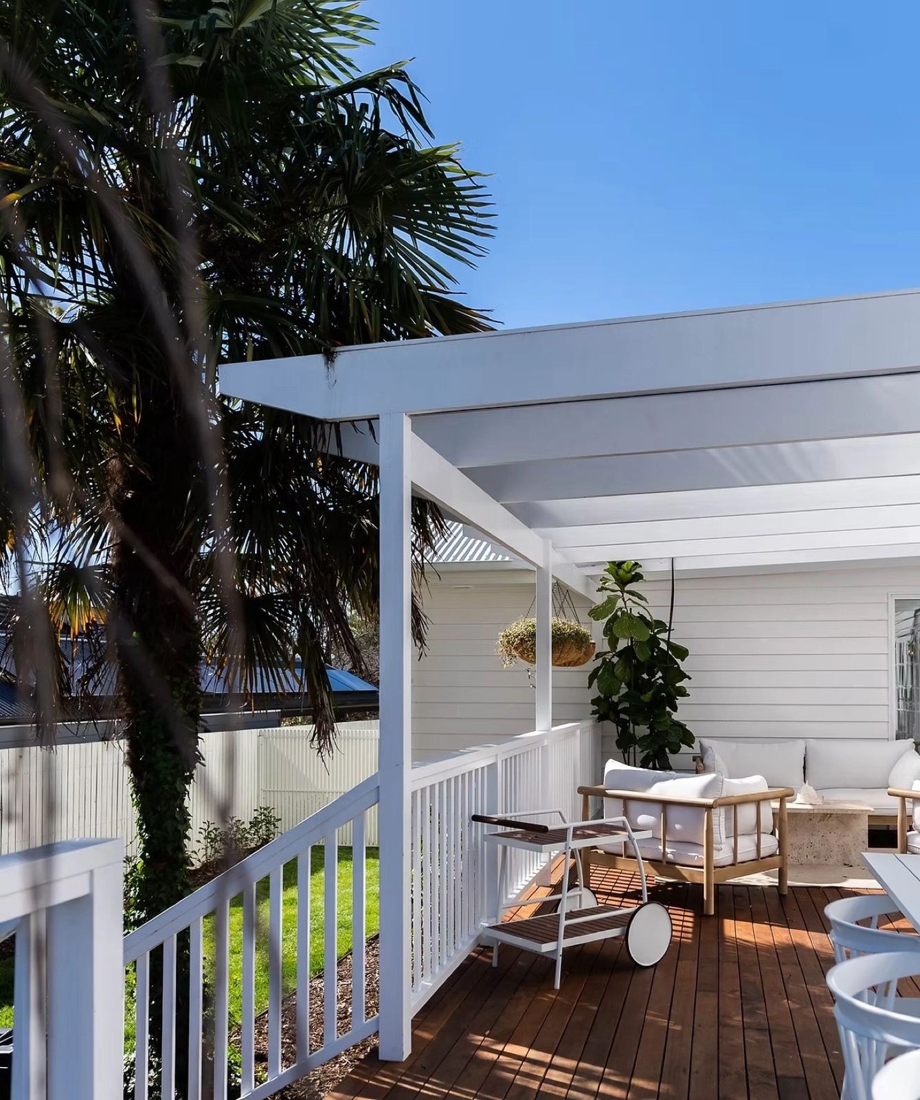 Alfresco deck under a white pergola with an outdoor lounge