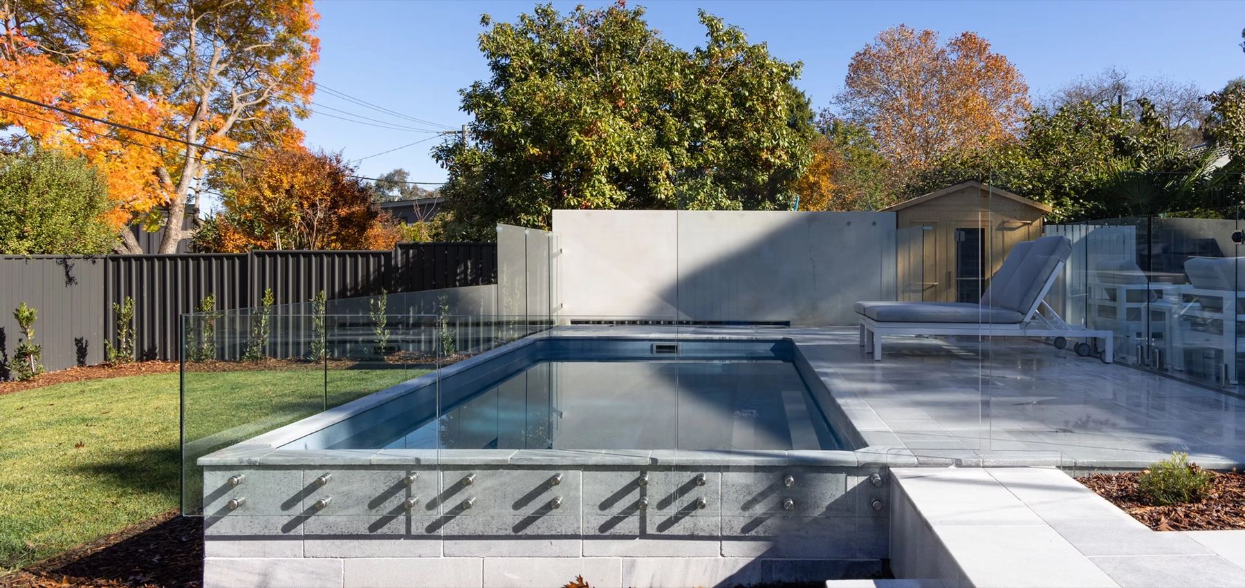 A resort-style pool framed by a clean material palette and mature planting