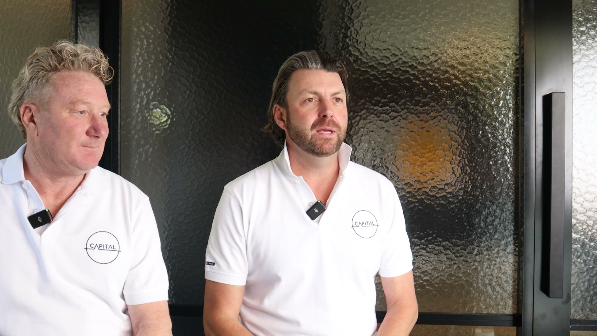 Capital DCM founders Michael and Richie seated together in matching studio polos